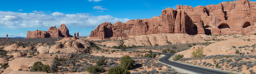 Fototapeta na wymiar Panoramic Landscape view of a Scenic road in the red rock canyons during a vibrant sunny day. Taken in Arches National Park, located near Moab, Utah, United States.