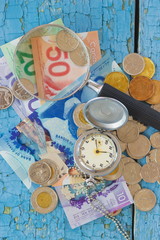 Canadian dollars, pocket clock, magnifying glass and coins on the wooden background