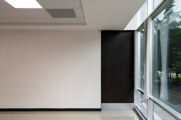 Interior of modern office with large window and wooden door, new space with reflections, latin...