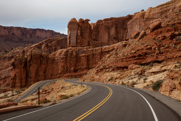 Scenic road in the red rock canyons during a vibrant sunny day. Taken in Arches National Park, located near Moab, Utah, United States.