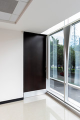 Fototapeta premium Interior of modern office with large window and wooden door, new space with reflections, latin america.