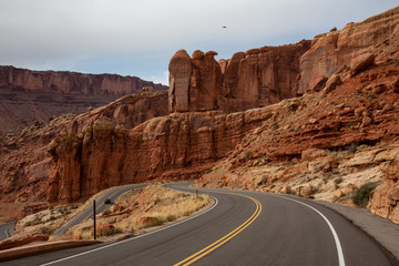 Scenic road in the red rock canyons during a vibrant sunny day. Taken in Arches National Park, located near Moab, Utah, United States.
