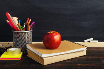 Teacher's desk with writing materials, a book and an apple, a blank for text or a background for a...