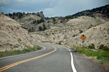 Road with traffic sign in hills in American desert