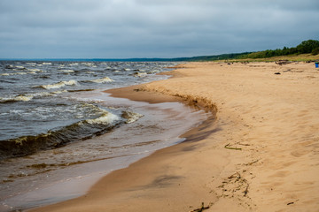 storm clouds forming over clear sea beach with rocks and clear sand