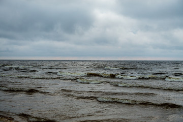 storm clouds forming over clear sea beach with rocks and clear sand