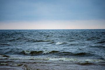 storm clouds forming over clear sea beach with rocks and clear sand