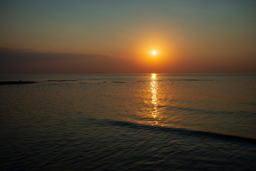 Naklejka premium dramatic red orange colored sunset over the calm sea at summer