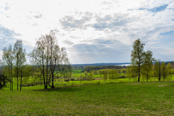 plain simple countryside spring landscape with fresh green meadows and forests