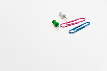 Büroklammern und Stecknadel auf weißem Hintergrund