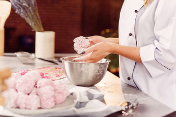 Chef preparing delicate homemade marshmallows with her hands. The concept of home cooking.