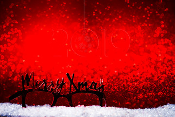 Obraz na płótnie Canvas Christmas party glasses wth christmas decoration, cozy home chrismtas, against a bokehlicious red background warm tone.