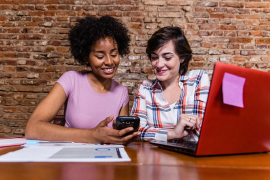Women working and looking at cell phone