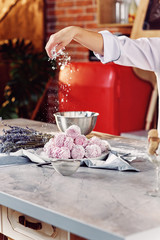 Close up hands of the chef sprinkles homemade marshmallows with sugar powder. Marshmallow preparation process. The concept of home cuisine.
