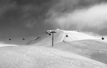 Black and white view on gondola lift and off-piste ski slope