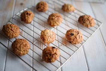 Appetizing and tasty oatmeal cookies with raisins and milk on a bright table.