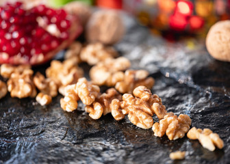  Nut, seeds, pomegranates with seeds on the natural black stone