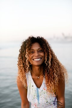 Fit, stylish woman enjoying sunset walk in ocean water