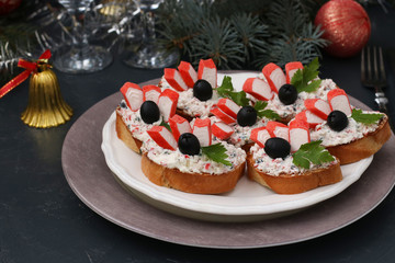 Festive sandwiches with crab sticks, feta cheese and black olives. Christmas background