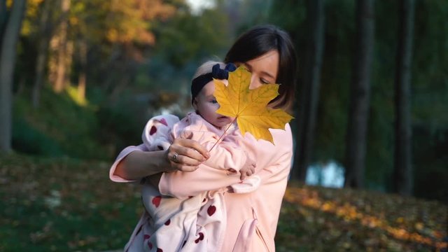 mom holds a beautiful baby in her arms, mom holds a piece of paper in her hands and shows her child