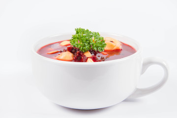 Traditional polish Christmas Eve dish: red borscht with uszka a mushroom filled kind of dumpling decorated with parsley 