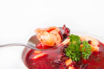 Traditional polish Christmas Eve dish: red borscht with uszko (a mushroom filled kind of dumpling) decorated with parsley eaten with a spoon