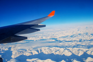 Obraz premium Wing aircraft over the mountains of Greenland