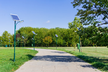 Park alley illuminated by solar powered street lights in Tineretului Park, Bucharest, Romania
