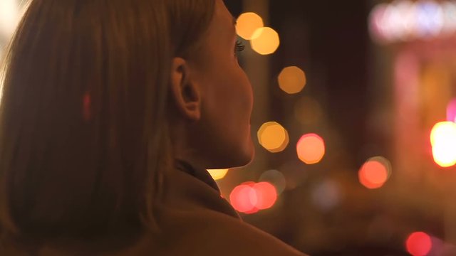 Attractive brunette lady looking at night city lights, megalopolis illumination