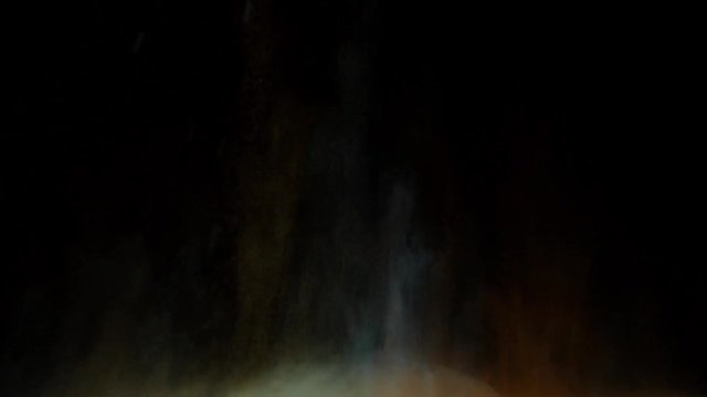 The explosion of colored dry ink on a black background