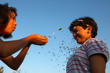 Cheerful girls making fun with confetti