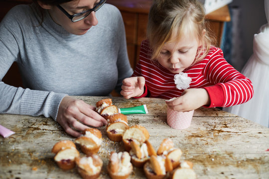 Woman and child making cupcakes together
