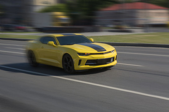 Fototapeta Yellow sports car racing down the city street