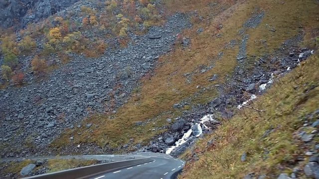 Driving trollstigen road in Norway crossing a waterfall