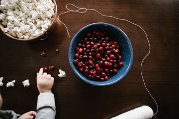Toddler helping make holiday garland