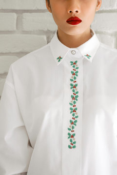 Red lips woman portrait in white Christmas embroidered shirt