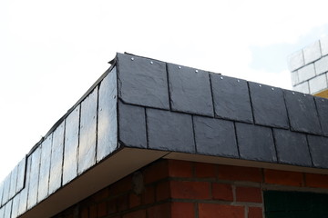 Obraz premium Dachdecken mit Naturschiefer Baumaterial auf Bauholz am Bauwerk, Freifläche als Textfreiraum 