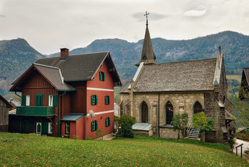 Fototapeta na wymiar Town of Grundlsee with the old parish church on a cloudy autumn day. Region of Salzkammergut, Federal state of Styria, Austria, Europe.