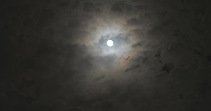 Full moon at night with moving clouds