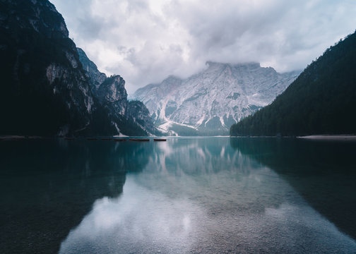 Lago di Braies just before the sunrise with snowy mountains at the background and still calm bank at the front