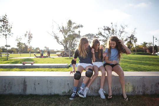 Friends and cousins playing together on skateboard outside