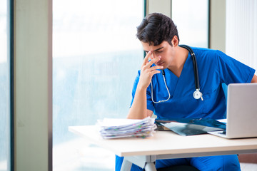 Young handsome doctor working in the hospital 