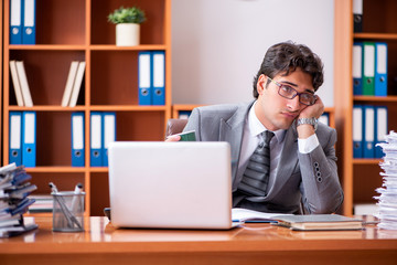 Fototapeta premium Young handsome businessman unhappy with excessive work 