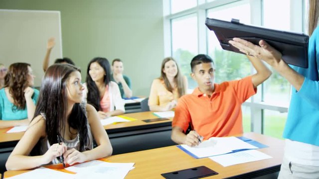 Smart Caucasian American female college tutor teaching class multi ethnic teenage students working for academic diploma  