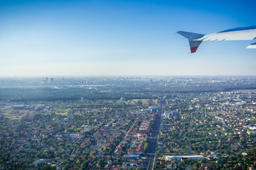 Taking off from Otopeni airport; flying over residential neighborhoods, Bucharest skyline in the background; Romania