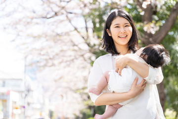 portrait of young asian mother and baby looking cherry blossom