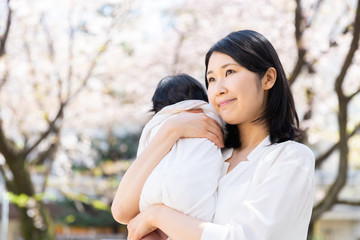 Obraz premium portrait of young asian mother and baby looking cherry blossom