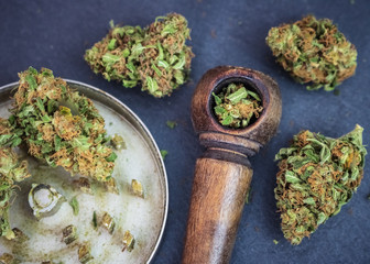 Marijuana buds up close with wooden pipe & steel grinder