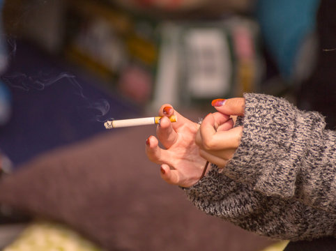 Woman Holding Burning Cigarette Indoors