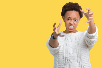 Beautiful young african american woman wearing sweater over isolated background Shouting frustrated with rage, hands trying to strangle, yelling mad